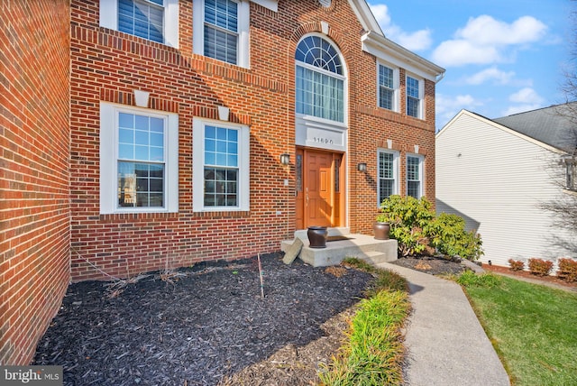 view of exterior entry featuring brick siding