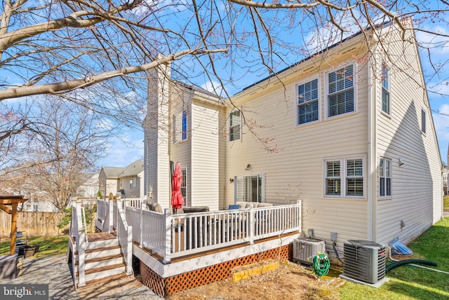 back of property with a deck, central AC, and a chimney