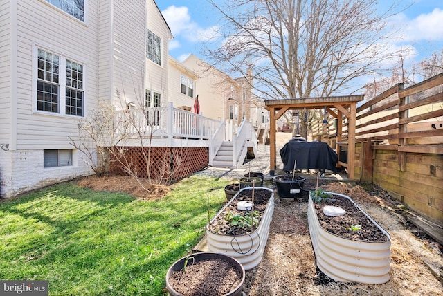 view of yard featuring a garden, fence, and a wooden deck