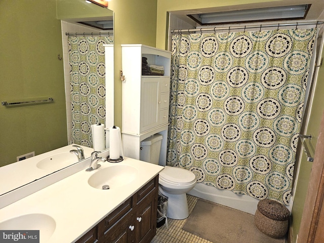 full bathroom featuring a sink, toilet, double vanity, and tile patterned floors