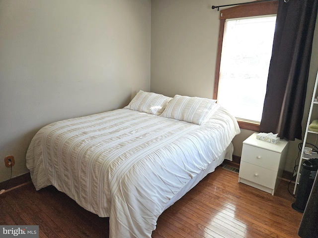 bedroom with multiple windows, wood-type flooring, and visible vents