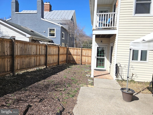 view of yard with a balcony and a fenced backyard