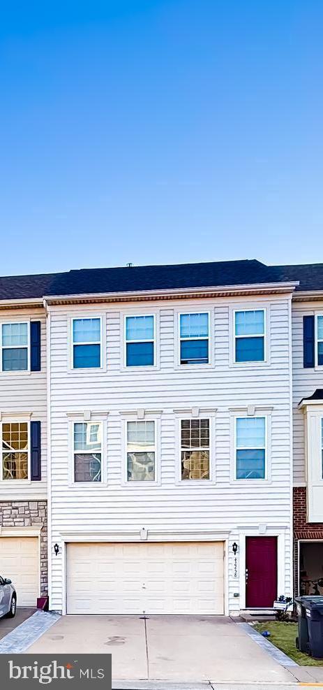 townhome / multi-family property featuring concrete driveway and an attached garage