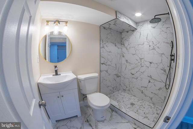 full bathroom with tiled shower, toilet, marble finish floor, and vanity