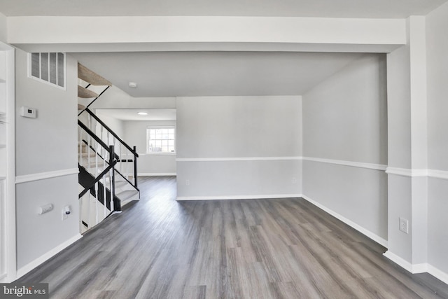 spare room featuring stairs, visible vents, wood finished floors, and baseboards