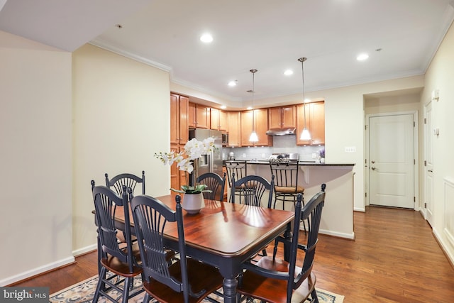 dining space with dark wood-style floors, recessed lighting, crown molding, and baseboards