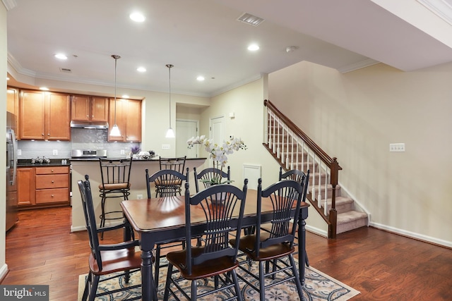 dining area with crown molding, visible vents, dark wood-style flooring, and baseboards