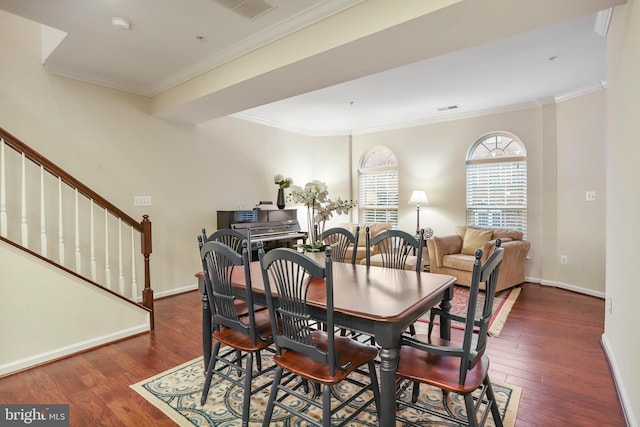 dining area with stairway, wood finished floors, baseboards, visible vents, and crown molding