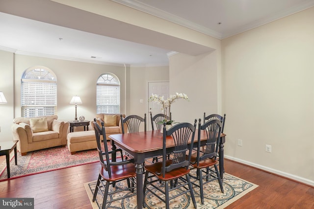 dining space featuring dark wood finished floors, visible vents, baseboards, and ornamental molding