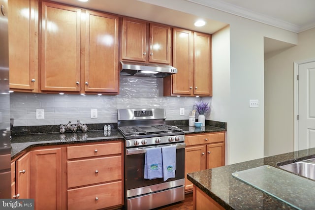 kitchen with under cabinet range hood, gas range, crown molding, and backsplash