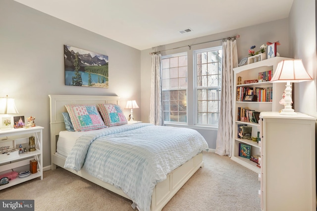 bedroom featuring baseboards, visible vents, and light carpet