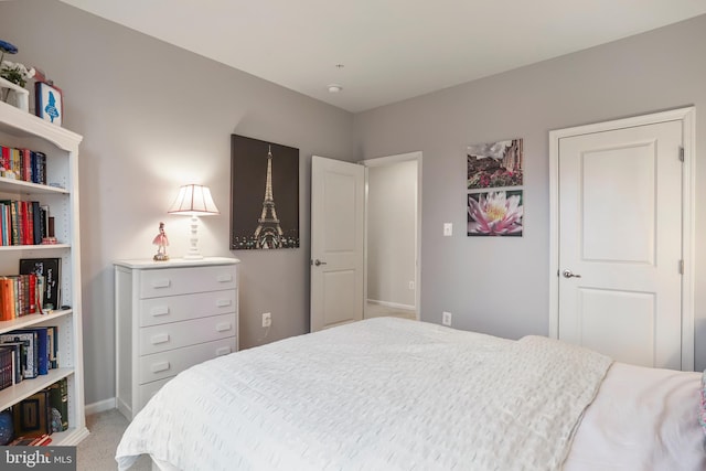 bedroom with light colored carpet and baseboards