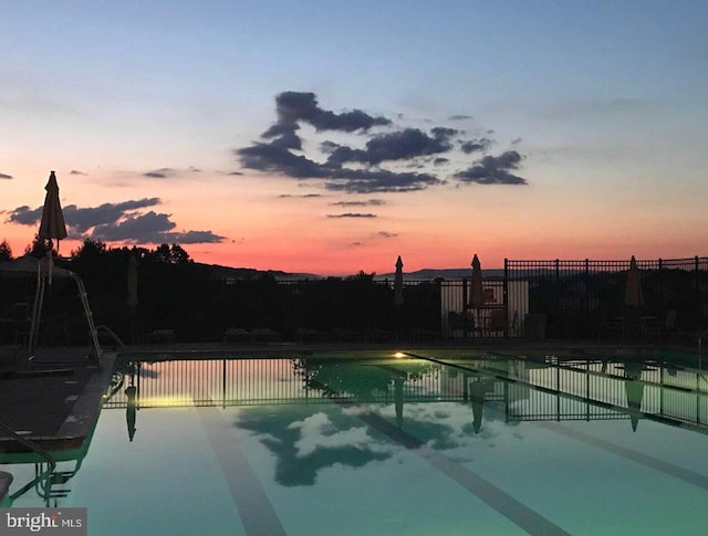 pool with a patio area and fence