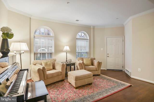 living area featuring a baseboard heating unit, plenty of natural light, wood finished floors, and visible vents