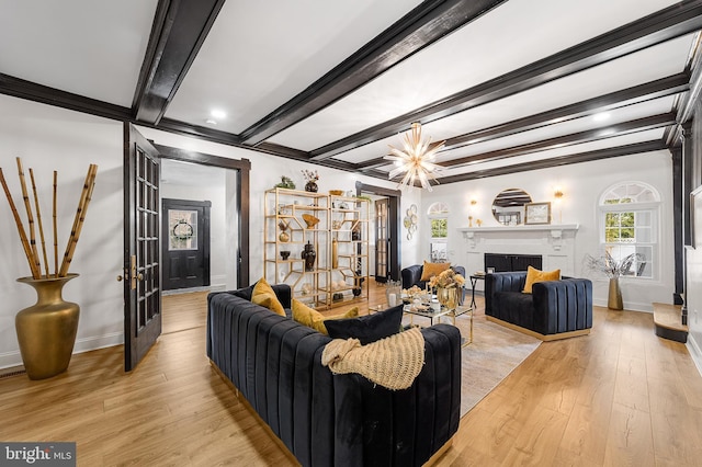 living room featuring beamed ceiling, a fireplace, baseboards, and light wood finished floors