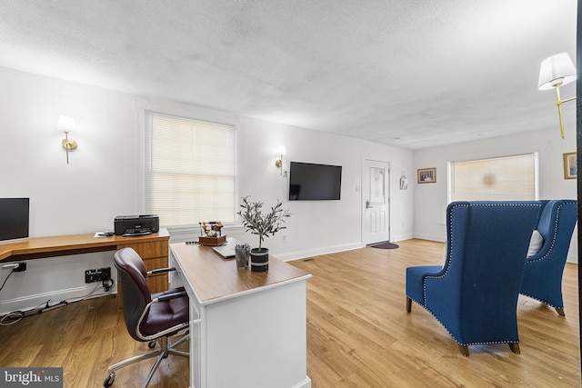 office area featuring wood finished floors, baseboards, and a textured ceiling