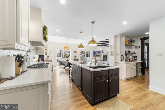 kitchen featuring light wood-style flooring, light countertops, and a sink