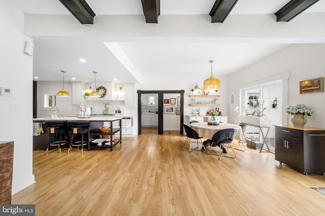 dining space with beam ceiling, recessed lighting, and light wood-style floors