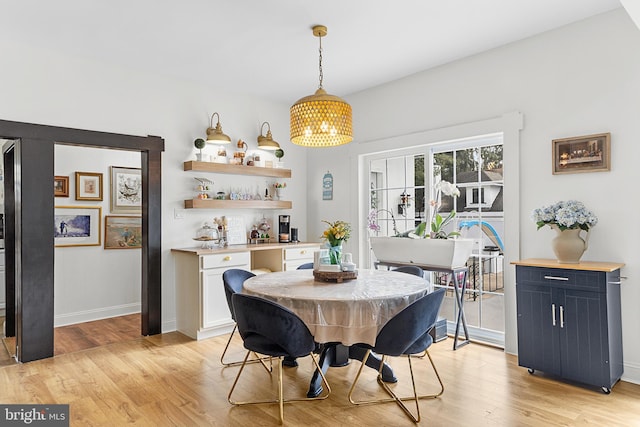 dining area featuring french doors, baseboards, and light wood finished floors