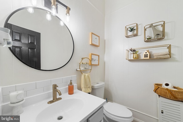 bathroom featuring backsplash, toilet, and vanity