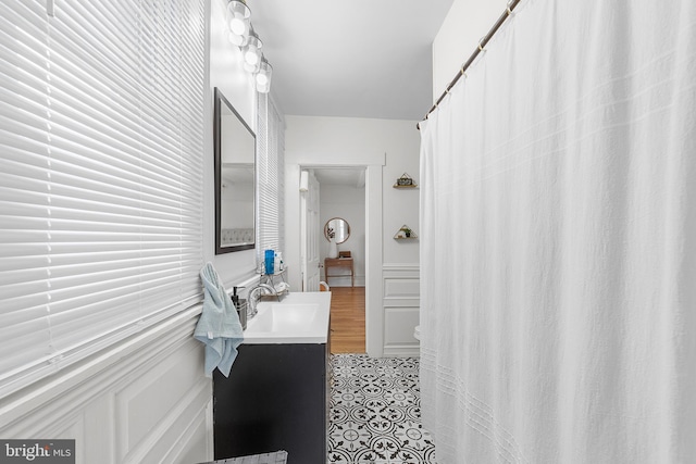 bathroom with vanity and a decorative wall