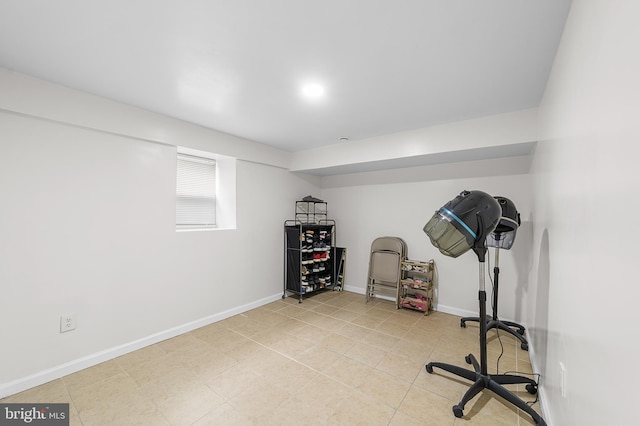 workout area featuring light tile patterned floors and baseboards