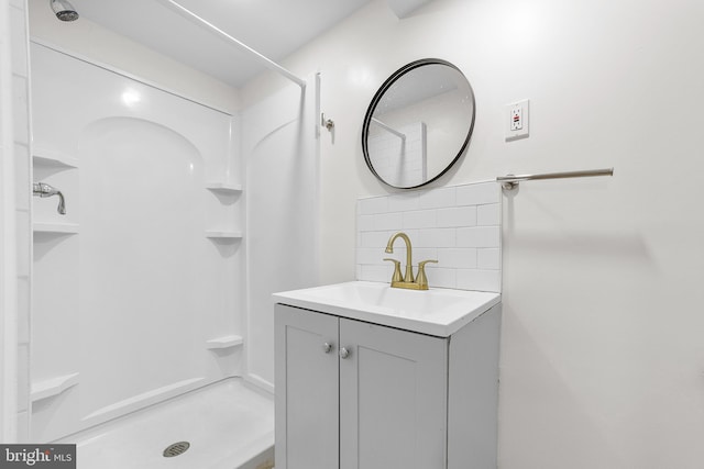 bathroom featuring decorative backsplash, vanity, and a shower stall