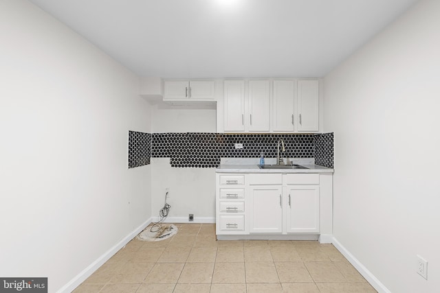 laundry room with light tile patterned floors, baseboards, and a sink