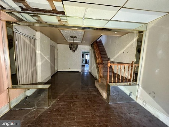 corridor with stairway, wood finished floors, and baseboards