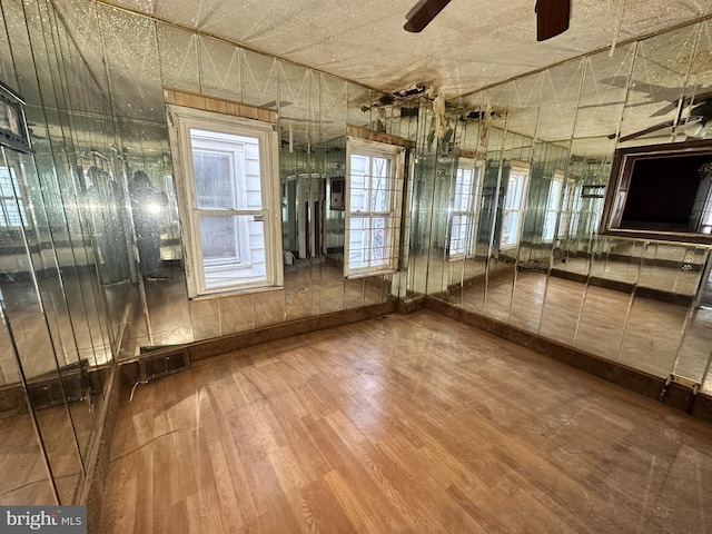 interior space with a ceiling fan and wood finished floors