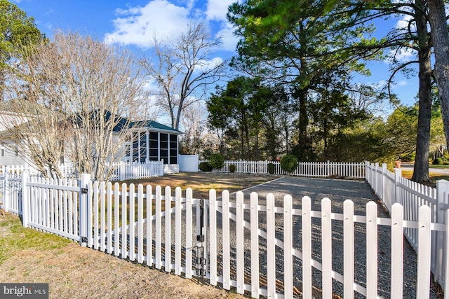 view of yard with a sunroom, a gate, and a fenced front yard