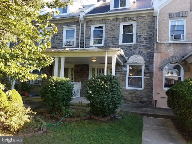 multi unit property with stone siding, covered porch, and cooling unit