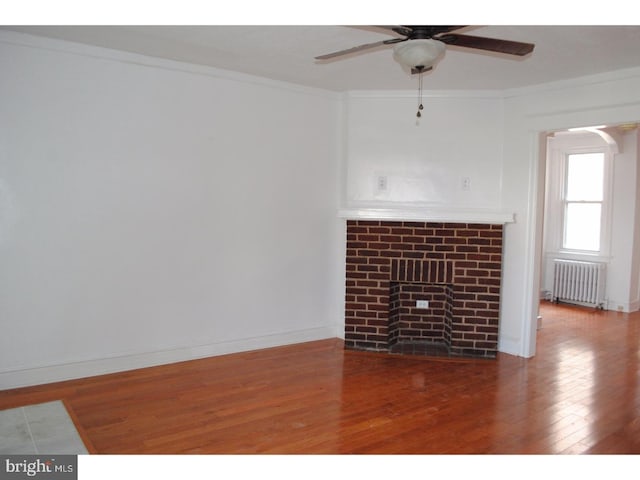 4408 Sherwood Rd, Philadelphia, PA 19131 - unfurnished living room with crown molding, a fireplace, radiator heating unit, and wood finished floors