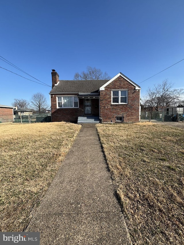 view of front of house featuring brick siding, a chimney, and a front lawn