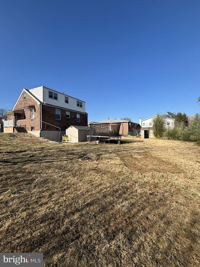 exterior space with brick siding and a trampoline