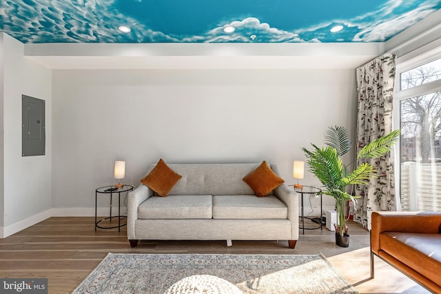 sitting room featuring electric panel, baseboards, and wood finished floors