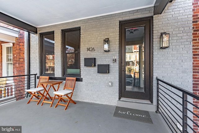 property entrance with brick siding and covered porch