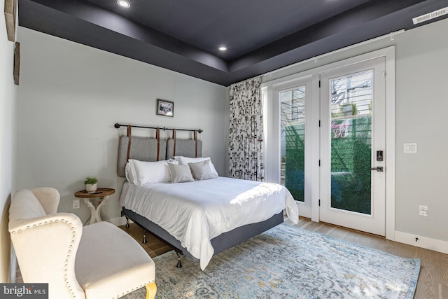 bedroom with access to exterior, recessed lighting, baseboards, and wood finished floors