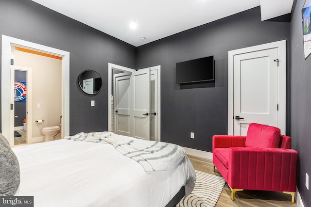 bedroom featuring light wood-style floors, baseboards, a closet, and connected bathroom