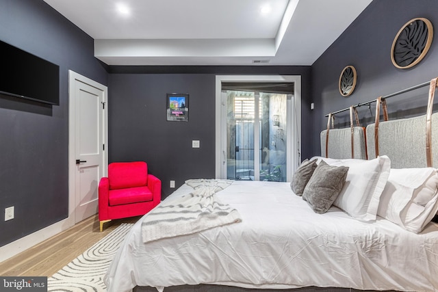 bedroom with access to exterior, baseboards, and wood finished floors