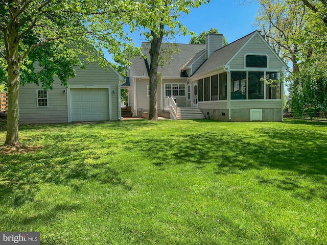 rear view of house with a lawn, a sunroom, and roof with shingles