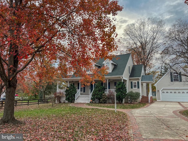 obstructed view of property with fence, driveway, a porch, a front lawn, and a garage