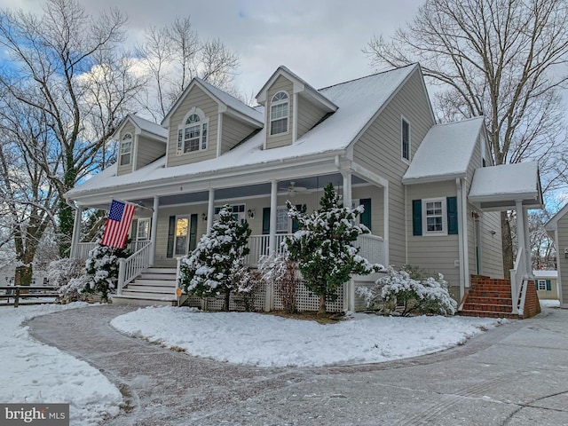 cape cod home featuring covered porch