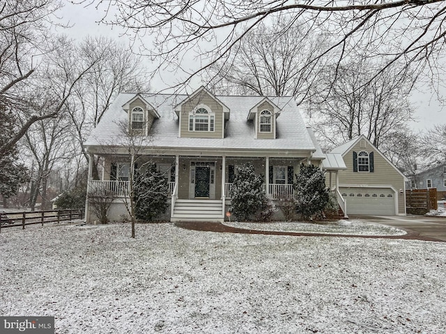 cape cod house with covered porch, concrete driveway, and fence