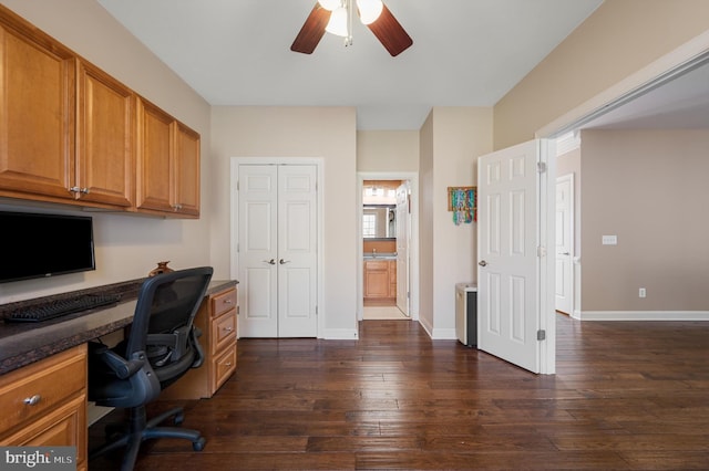 home office with dark wood finished floors, built in study area, baseboards, and ceiling fan