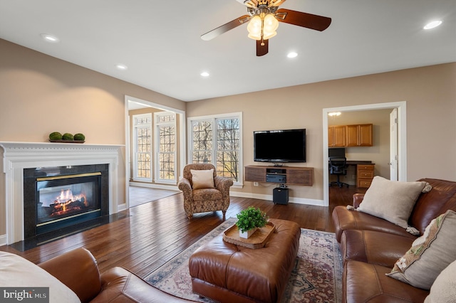 living room with a ceiling fan, baseboards, dark wood finished floors, a fireplace with flush hearth, and recessed lighting