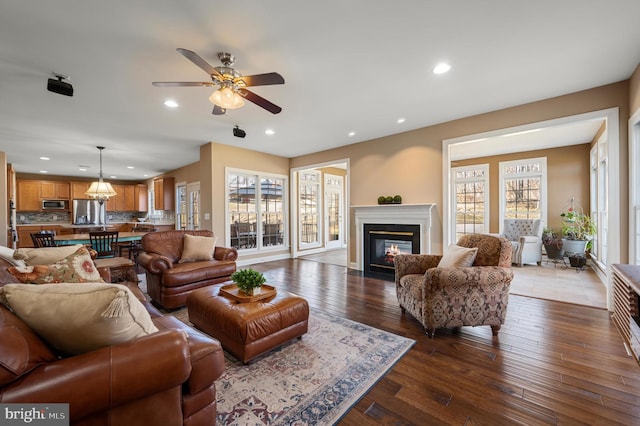 living area with a fireplace with flush hearth, recessed lighting, a ceiling fan, and wood-type flooring