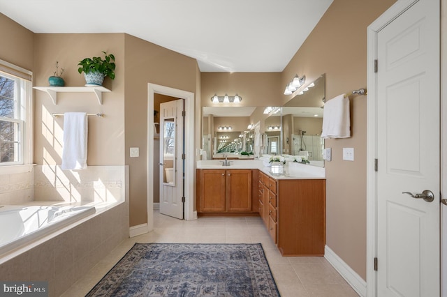 bathroom with vanity, tile patterned floors, a bath, and baseboards