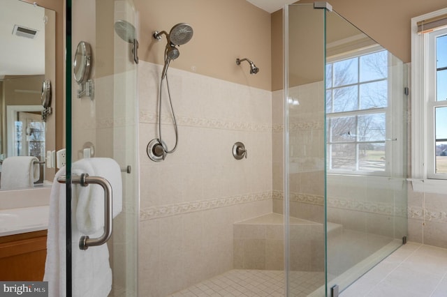 bathroom featuring visible vents, a stall shower, and vanity