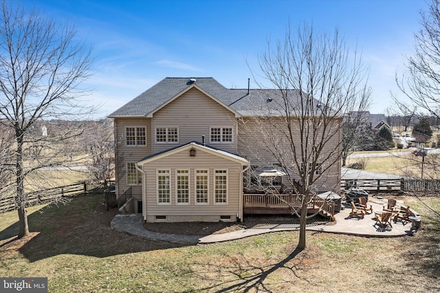 back of property featuring a deck, fence, a fire pit, roof with shingles, and a patio area